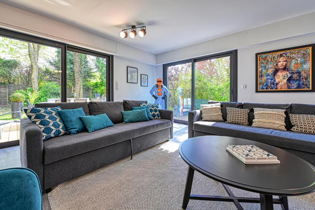 a living room with two couches and a table at Villa contemporaine 7 minutes du Centre de Lille in Marcq-en-Baroeul