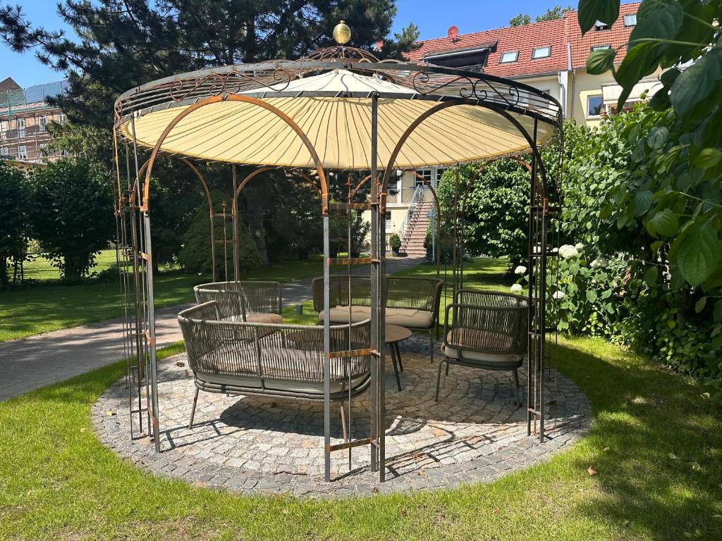 a gazebo with a table and chairs under it at Apartmenthaus Villa Lindenbühl in Mühlhausen
