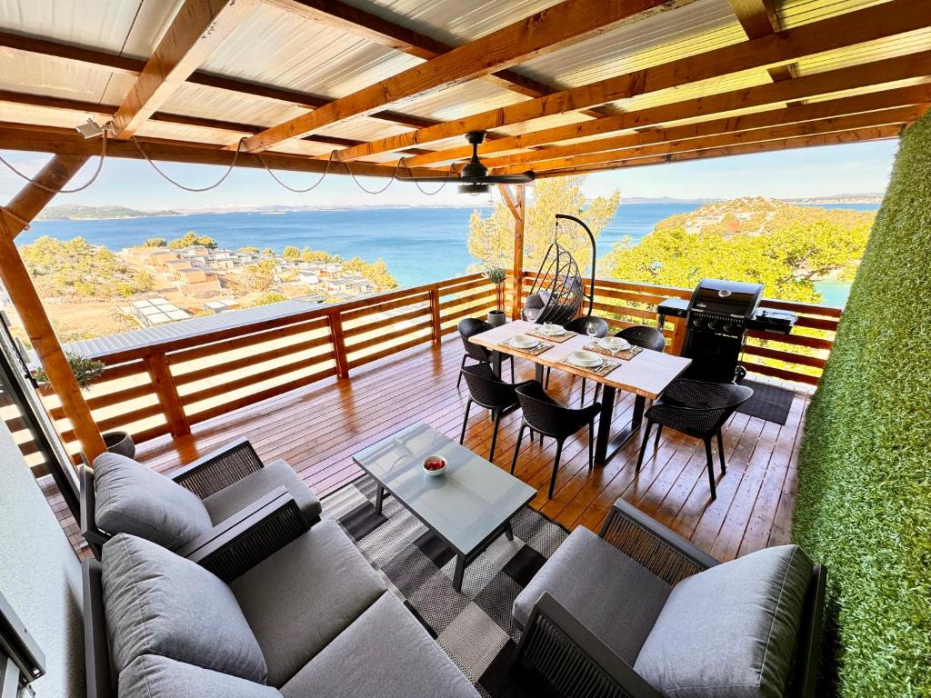 a patio with a table and chairs on a deck at d-view Premium Mobile Home - panoramic seaview - 150 m from beach, free parking in Drage
