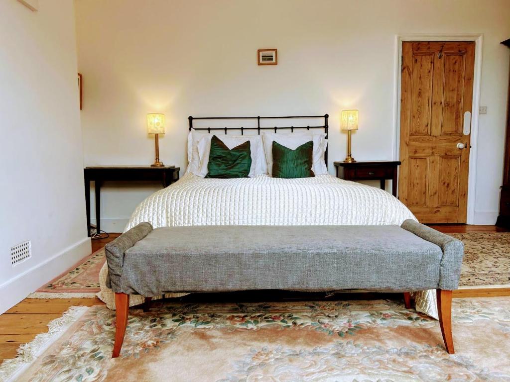 a bedroom with a large bed with green pillows at Large Sunny King-Size En-Suite in Hastings