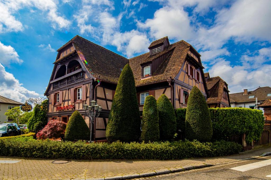a brown house with a roof at Hôtel Restaurant Relais De La Poste - Strasbourg Nord in La Wantzenau