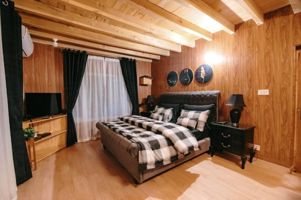 een slaapkamer met een bed en een flatscreen-tv bij Sakura Hunza Lodges in Baltit