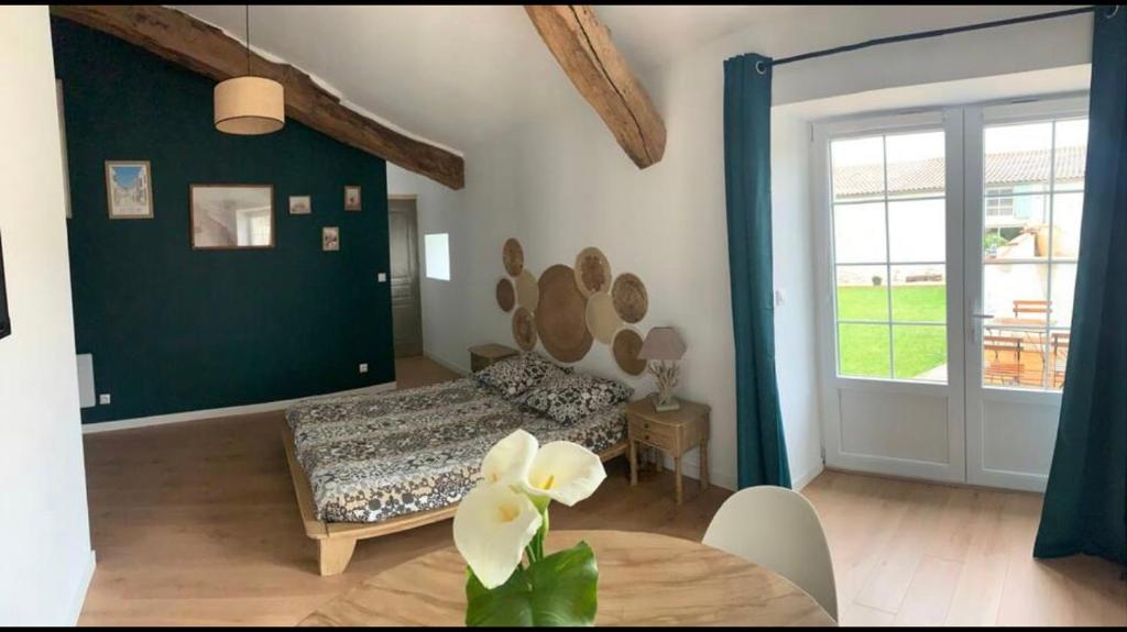 um quarto com uma cama, uma mesa e uma porta em Chambre Au clos des auges em Saint-Saturnin-du-Bois