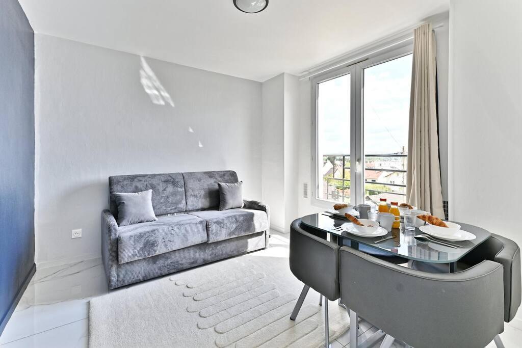 ein Wohnzimmer mit einem Sofa und einem Glastisch in der Unterkunft Magnifique 2 pieces aux portes de Paris in Gagny