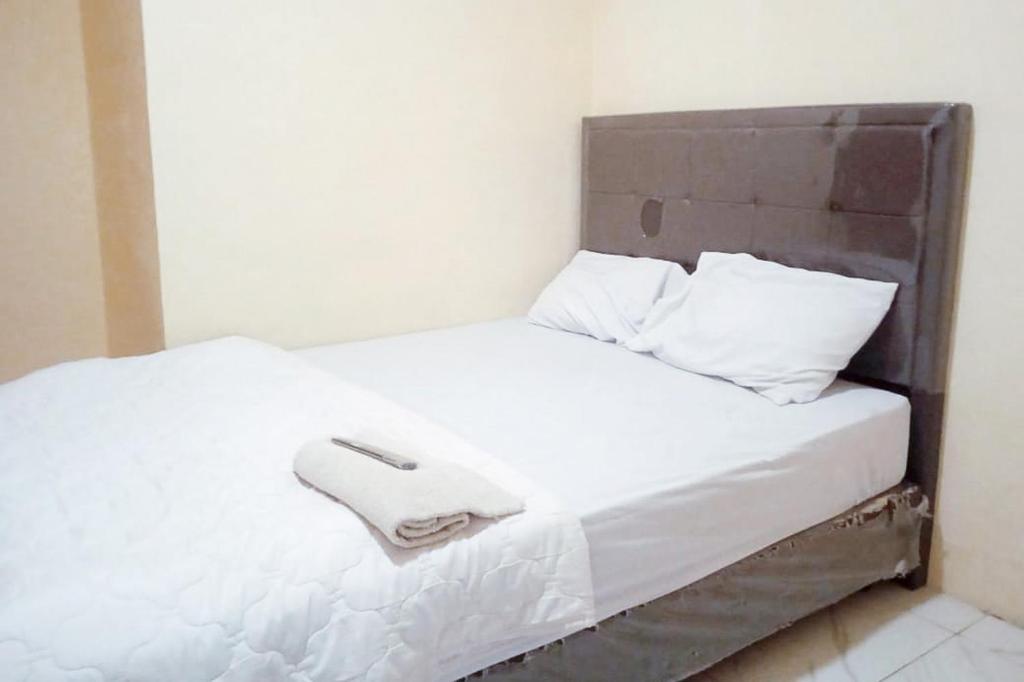 Tempat tidur dalam kamar di Makaliwe Mitra RedDoorz