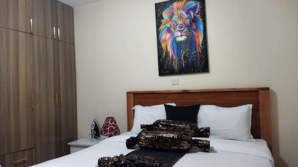Un dormitorio con una cama con un cuadro en la pared. en Cozy accommodations, en Naivasha