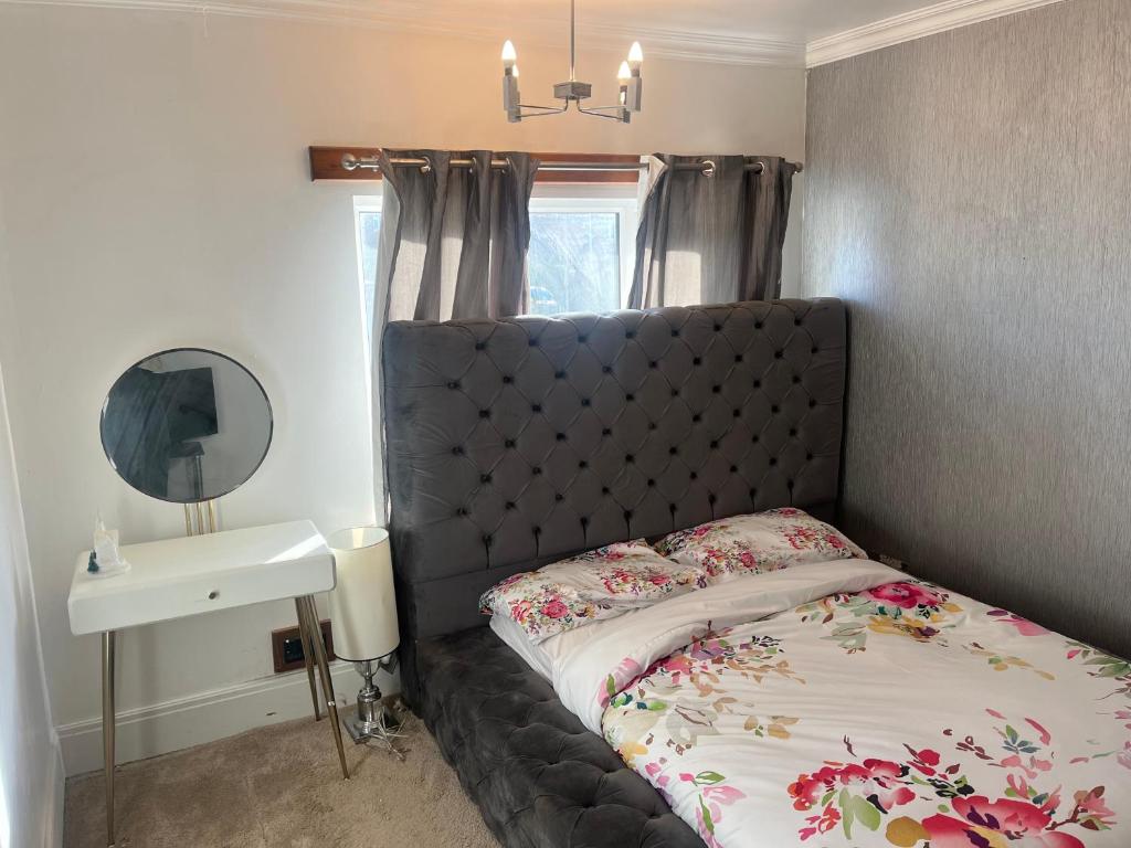 a bedroom with a bed with a black headboard and a sink at AICHELON Lodge in Wakefield