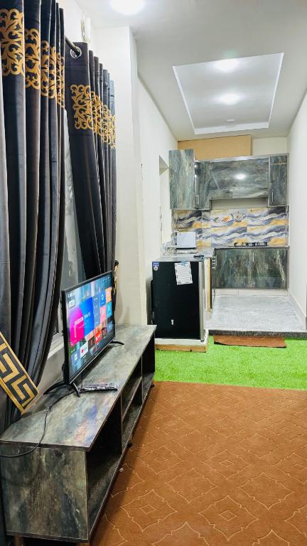 une chambre avec une télévision assise sur un banc et des rideaux dans l'établissement Rahat Arcade, à Islamabad