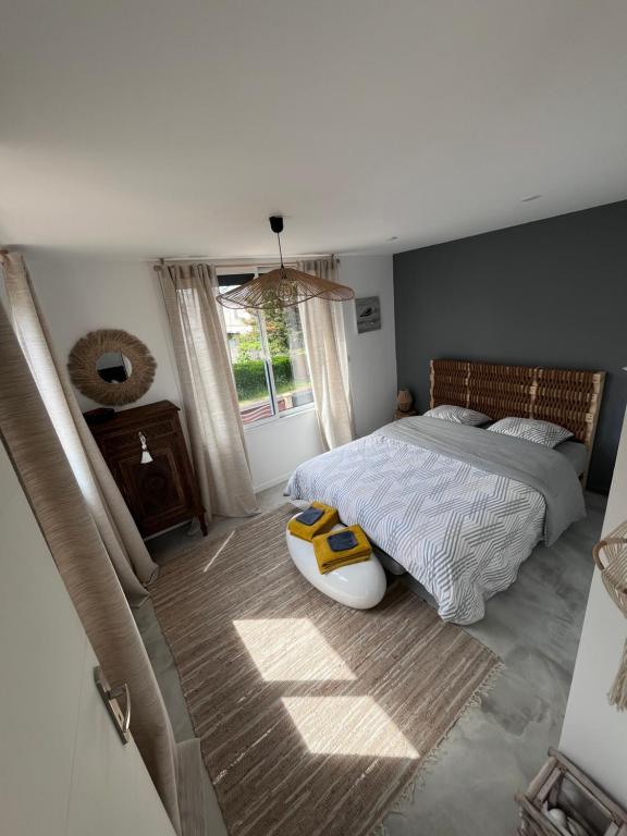 Un dormitorio con una cama grande y una ventana en la Villa des Cigales, en Coudeville
