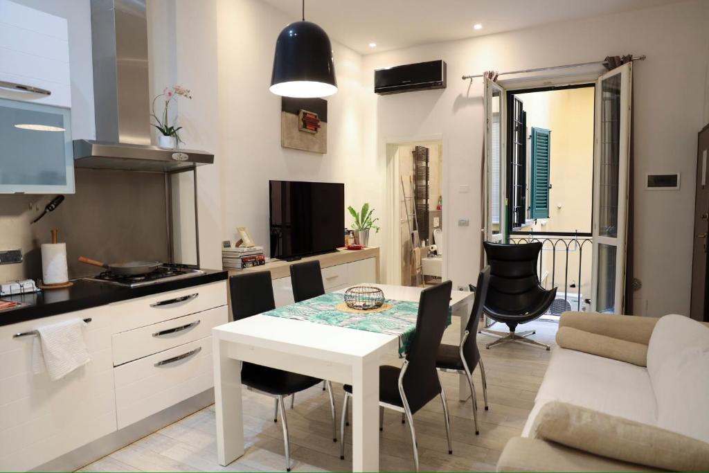 cocina y sala de estar con mesa y sillas en Appartamento Righi24 en Bolonia