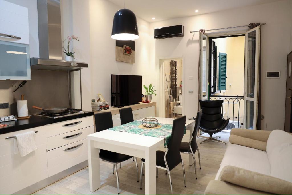 a kitchen and living room with a table and chairs at Appartamento Righi24 in Bologna