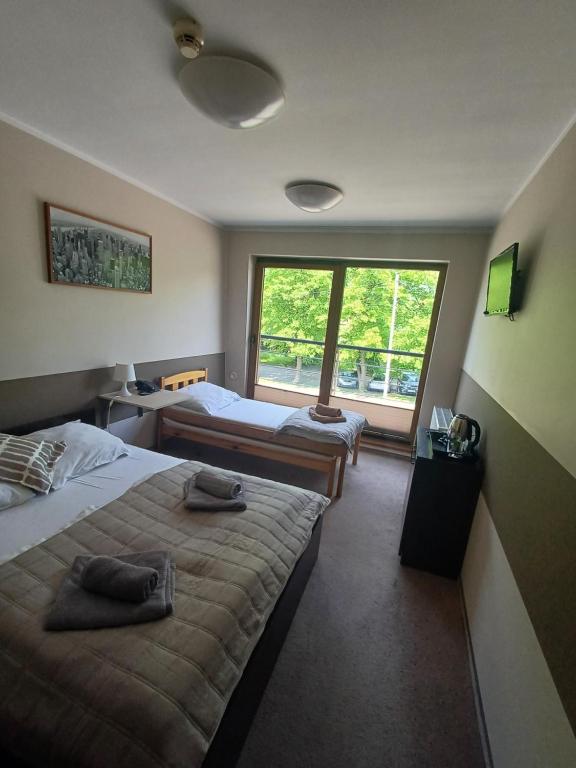 Habitación de hotel con 2 camas y ventana en Noclegi PAŃSKA Góra, en Andrychów