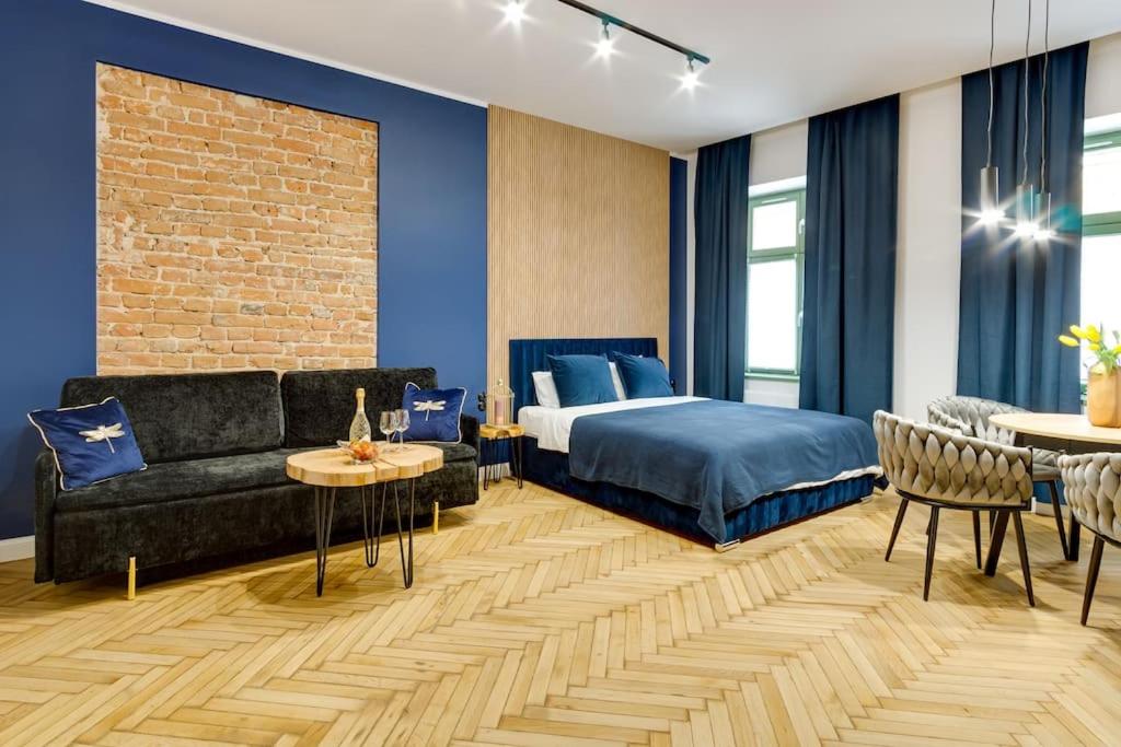 a bedroom with a bed and a couch and a table at Więzienna Old Town in Wrocław