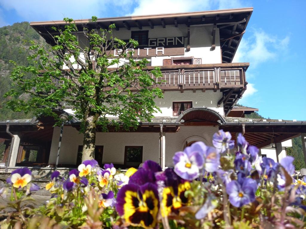 een gebouw met bloemen ervoor bij Albergo La Gran Baita in Tartano