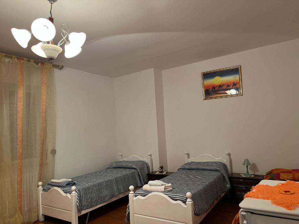 - une chambre avec 2 lits et une photo sur le mur dans l'établissement Stanze private in appartamento, à Udine