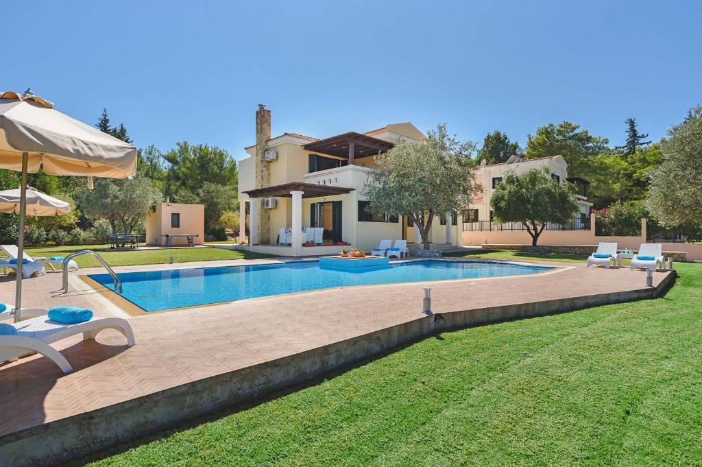 a house with a swimming pool in a yard at Seven Springs Villas Artemis Villa in Kolimbia