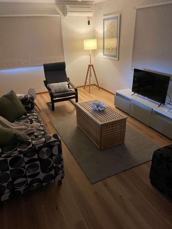- un salon avec un canapé, une table et une télévision dans l'établissement Daisy House - Whittington - 10 minutes to central Geelong, 