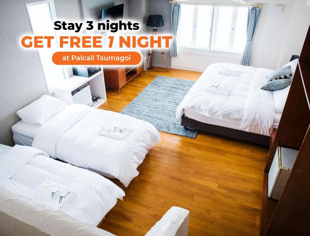 a room with two beds and a sign that says stay nights get free night at Active Life Madarao in Iiyama