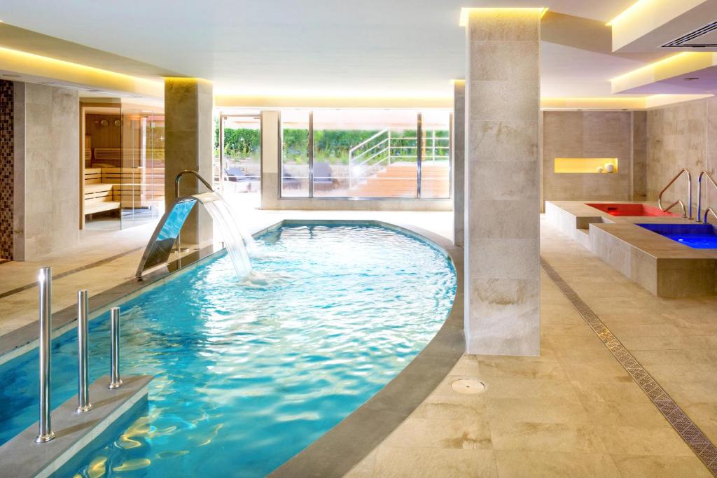 a pool with a water slide in a hotel room at VIVA Blue & Spa in Playa de Muro