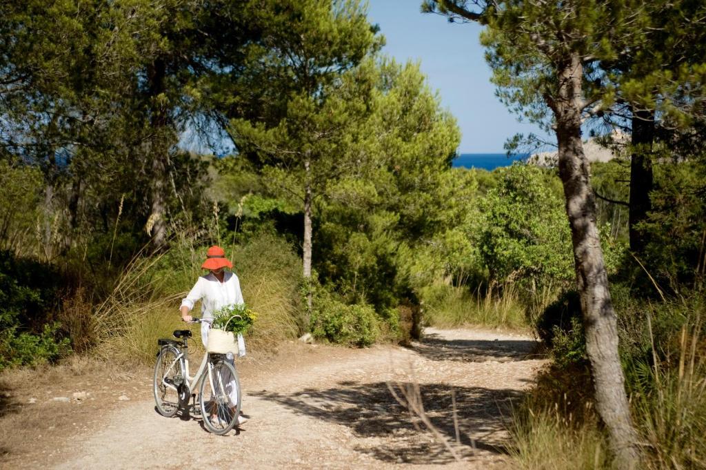 uma pessoa a andar de bicicleta numa estrada de terra batida em Predi Son Jaumell Hotel Rural em Capdepera