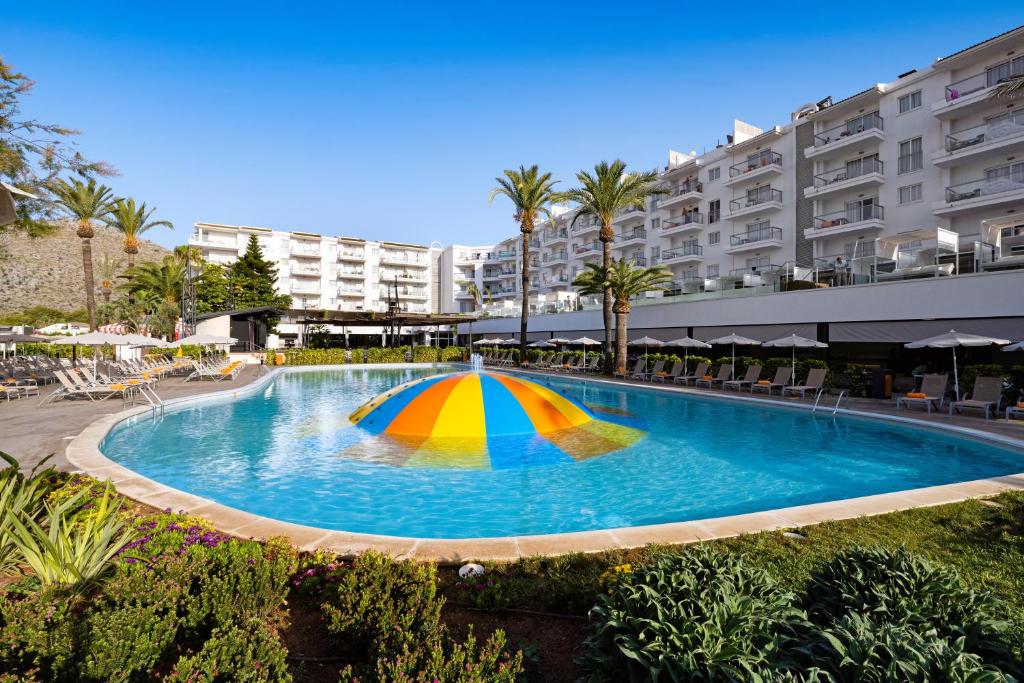 a pool with a colorful umbrella in the middle at VIVA Sunrise in Port d'Alcudia