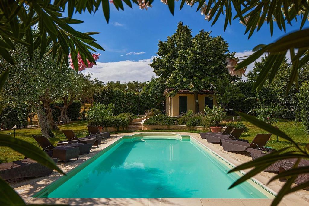a swimming pool in a yard with chairs and trees at Villa delle Marche by BarbarHouse in Rosciano