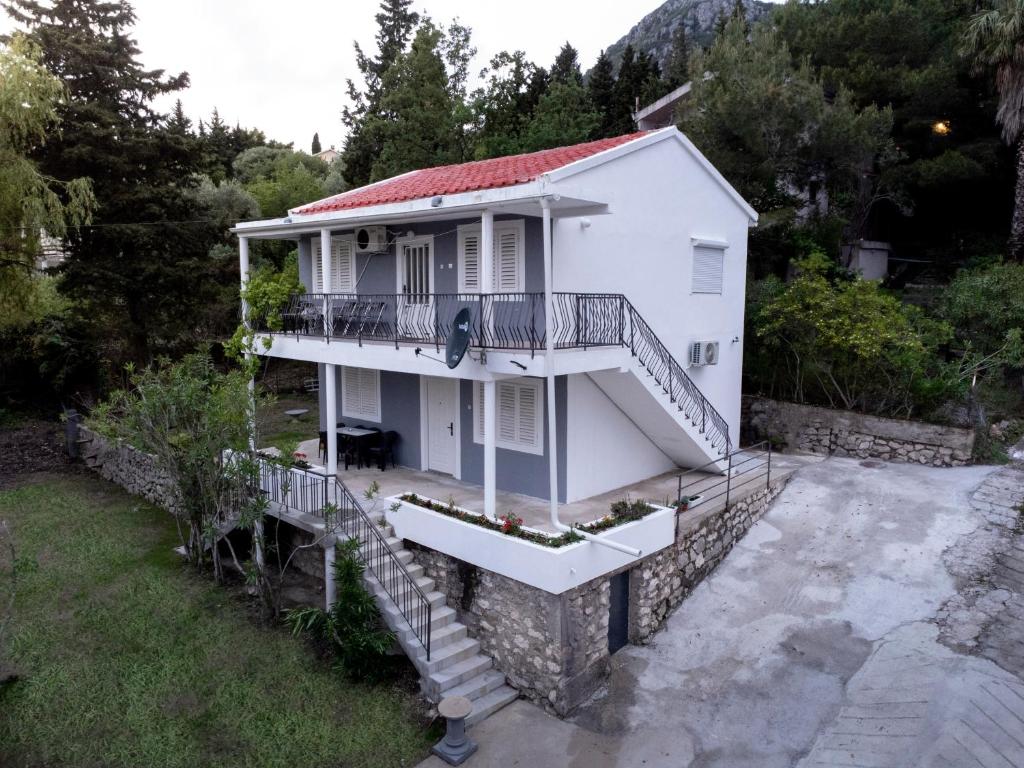 a white house with stairs and a balcony at Apartments Matija in Sutomore