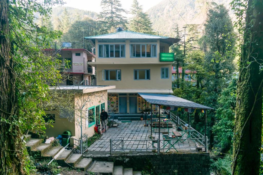 una casa en una colina en medio de un bosque en Eevolve Dharamkot - An Eco Hostel en McLeod Ganj