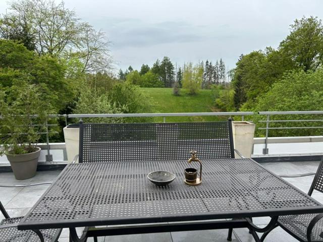 einem schwarzen Tisch mit einer Schüssel und einer Glocke auf dem Balkon in der Unterkunft TH 615 Panoramic Hohegeiß in Braunlage