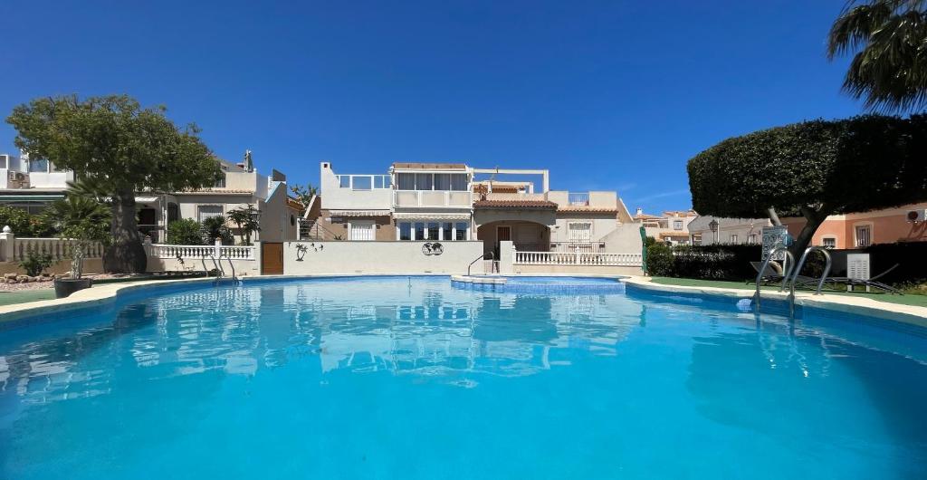 duży niebieski basen przed domem w obiekcie Holiday home with large roof terrace near La Mata beach w mieście Torrevieja