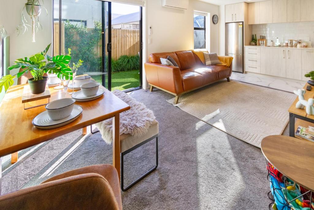a living room with a couch and a table at Gorgeous in Green - 2 bed Central Oasis w/king bed in Christchurch