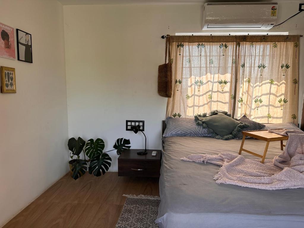 een slaapkamer met een bed, een raam en een tafel bij Room stay near HAMPI in Koppal