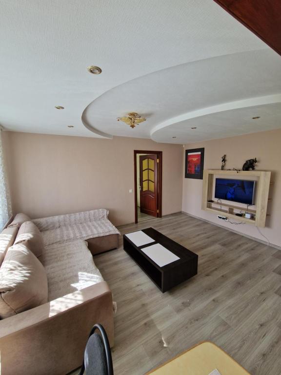 sala de estar con sofá y TV en Olimp, en Daugavpils