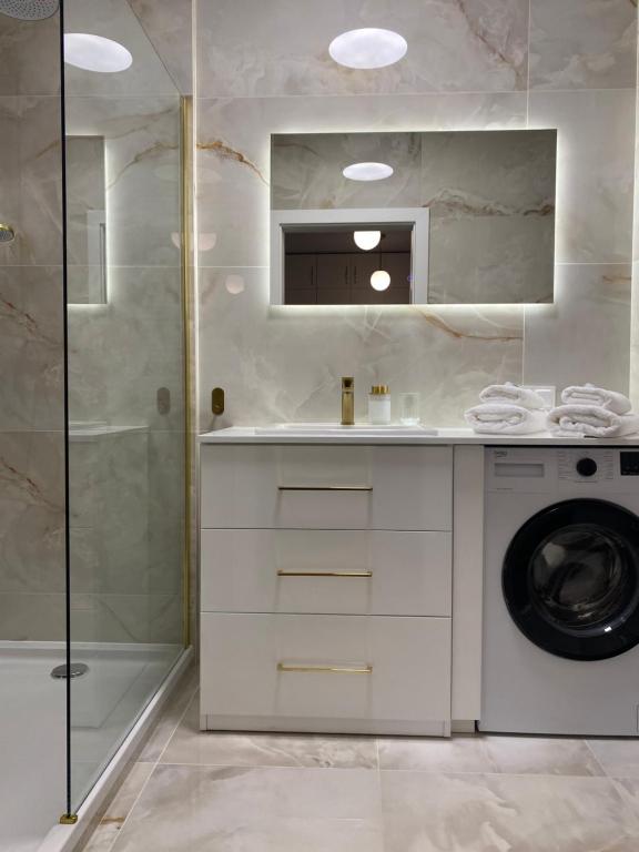 łazienka z pralką i prysznicem w obiekcie Komfi Apartment w mieście Białystok