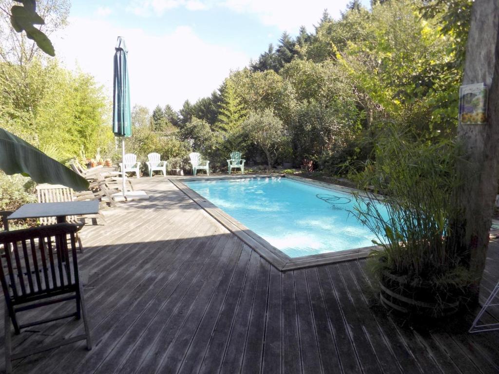 una piscina con una mesa y sillas en una terraza en LE DINANGA en Léran