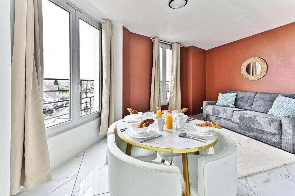 un salon avec une table et un canapé dans l'établissement Appartement moderne et spacieux 2 chambres - Gagny, à Gagny