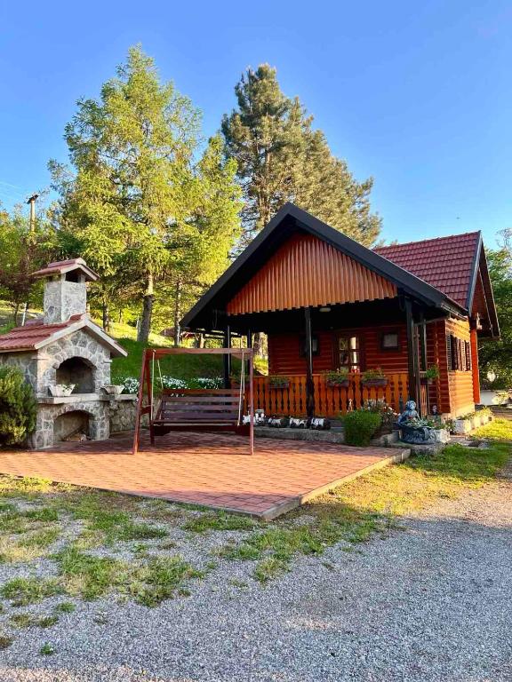 a log cabin with a porch and a stone oven at Holiday Home Manda in Tounj