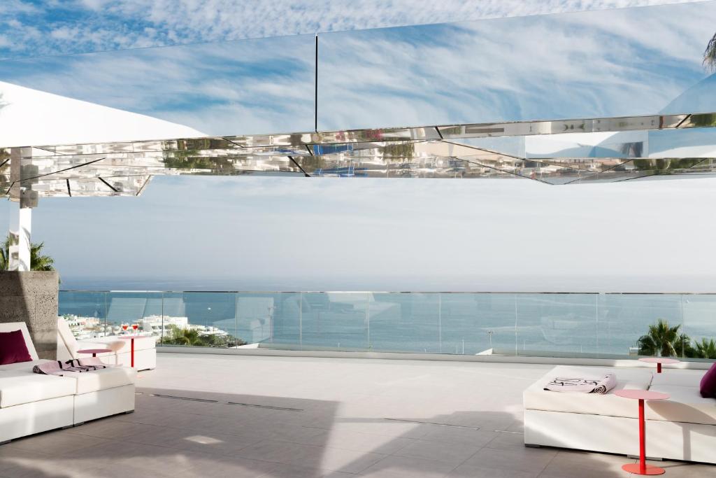 a living room with white furniture and large windows at La Isla y el Mar, Hotel Boutique in Puerto del Carmen