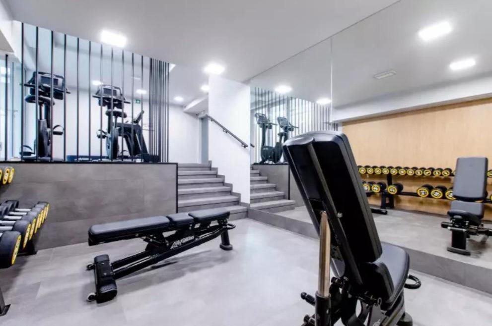 a gym with a bench and dumbbells at Apartament Holiday Crystal in Rewal