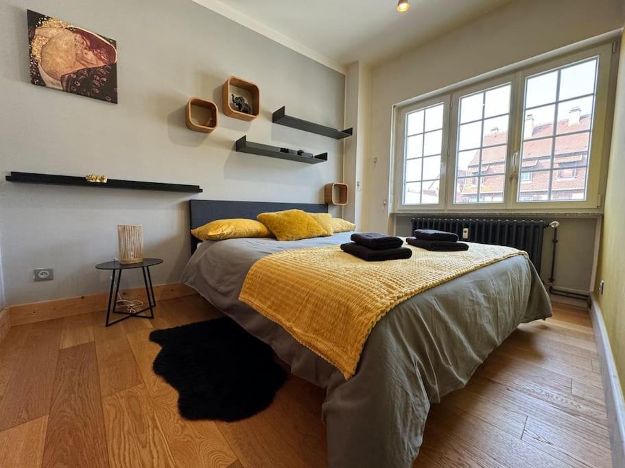 um quarto com uma cama grande e um cobertor amarelo em L'Arsenal - Appartement Centre ville - Poche commerces & restaurant - 6 P em Sélestat