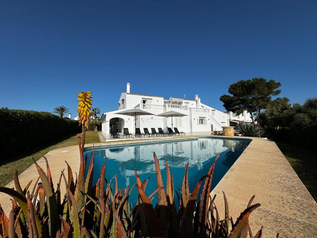 a large white house with a swimming pool in front of it at Villa Savanna in Cala en Blanes