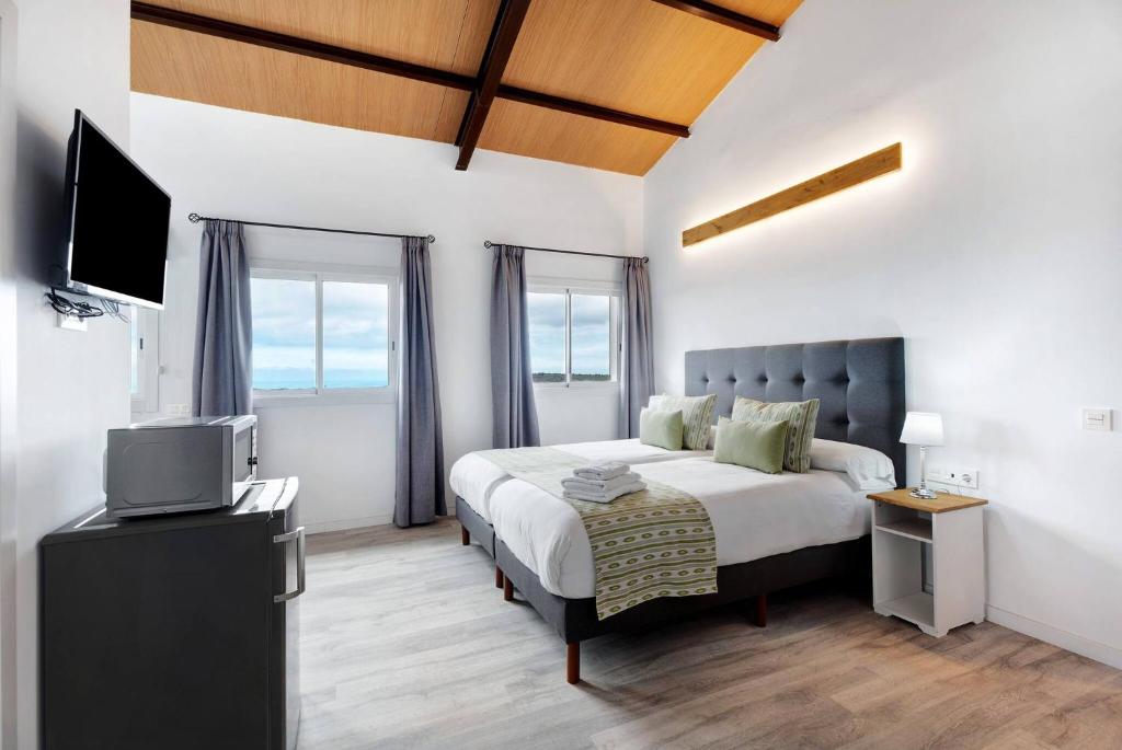 um quarto com uma cama e uma televisão de ecrã plano em Charming and comfortable apartment Casa Lomo El Aire Helecho em Tegueste