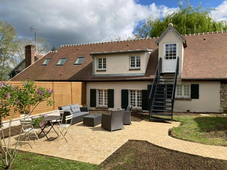 une maison avec un escalier en colimaçon dans la cour dans l'établissement La Petite Bergerie 3 etoiles, à Dampsmesnil