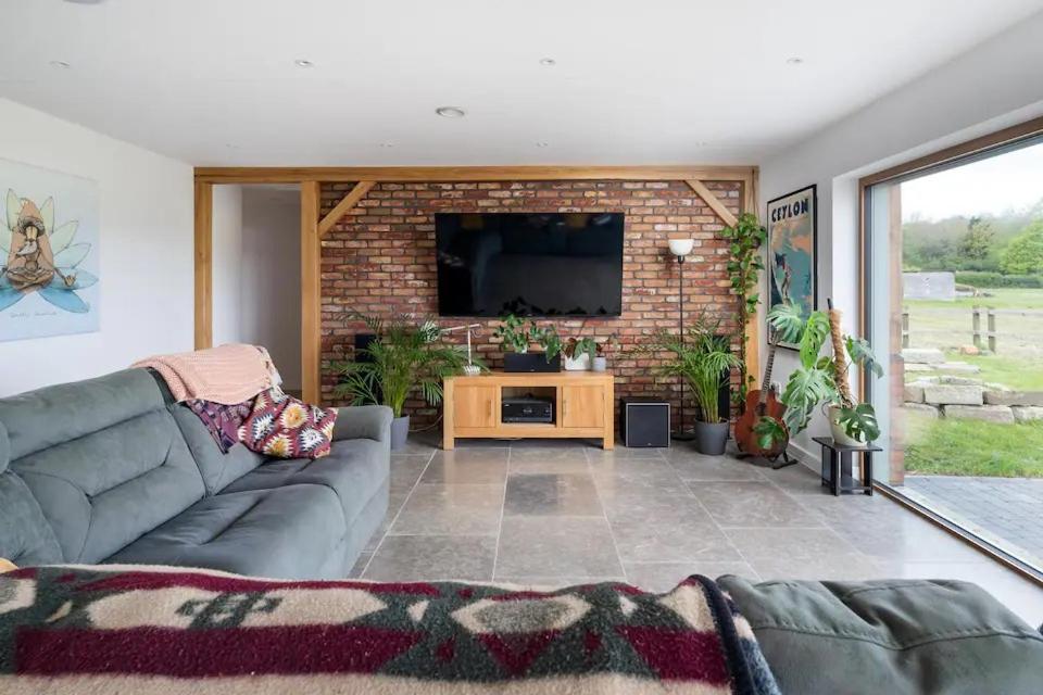 エルスツリーにあるModern 4 Bed Bungalow - Peaceful Rural Setting Pass the Keysのソファとテレビのあるリビングルーム