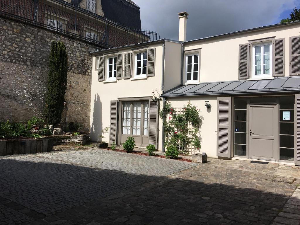 Uma casa branca com uma entrada à frente. em L'Octroi em Chartres