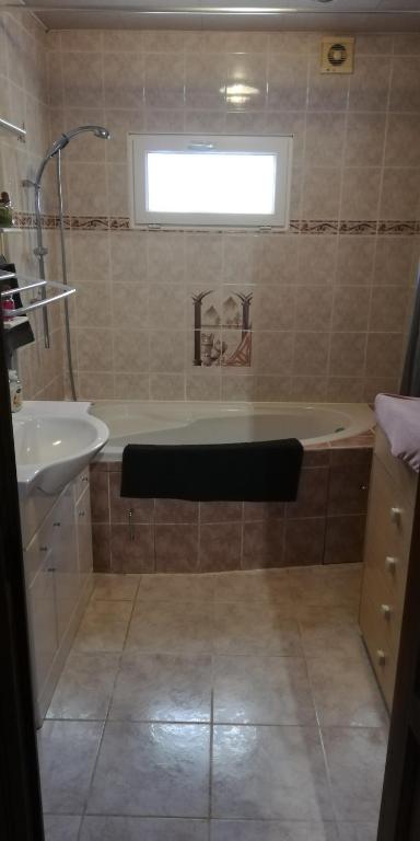 a bathroom with a bath tub and a sink at L&#39;éveil in Vittefleur