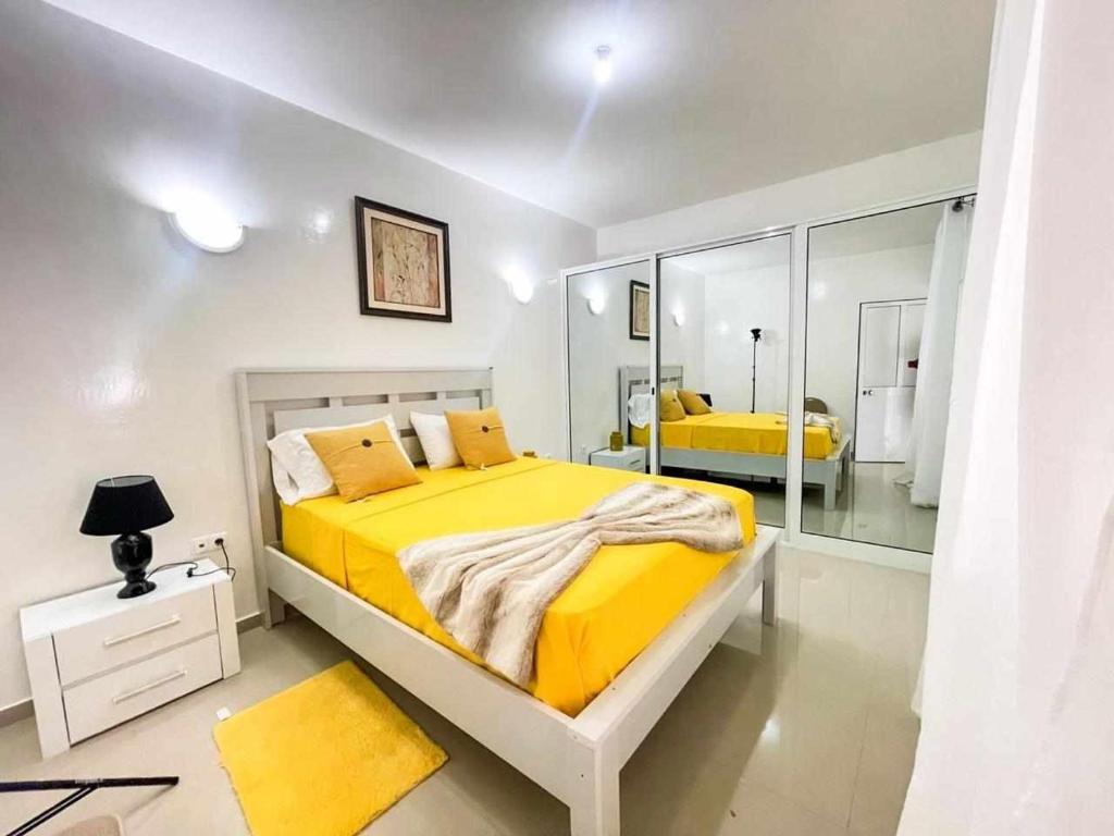 1 dormitorio con cama amarilla y espejo en Zeyden Place Apt 2, en Praia