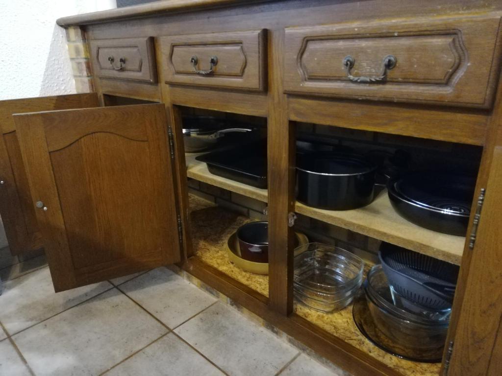 a kitchen cabinet with pots and pans in it at L&#39;éveil in Vittefleur