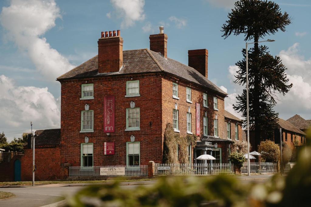 un gran edificio de ladrillo rojo con 2 chimeneas en Old Orleton Inn en Wellington