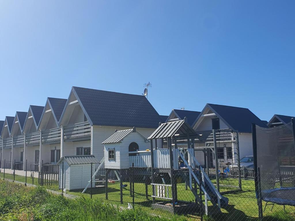 a row of houses with a playground in front at Sarbinowo Prestige - Ekskluzywne domki nad morzem in Sarbinowo